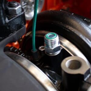 A close up of an oil filter on the side of a car.