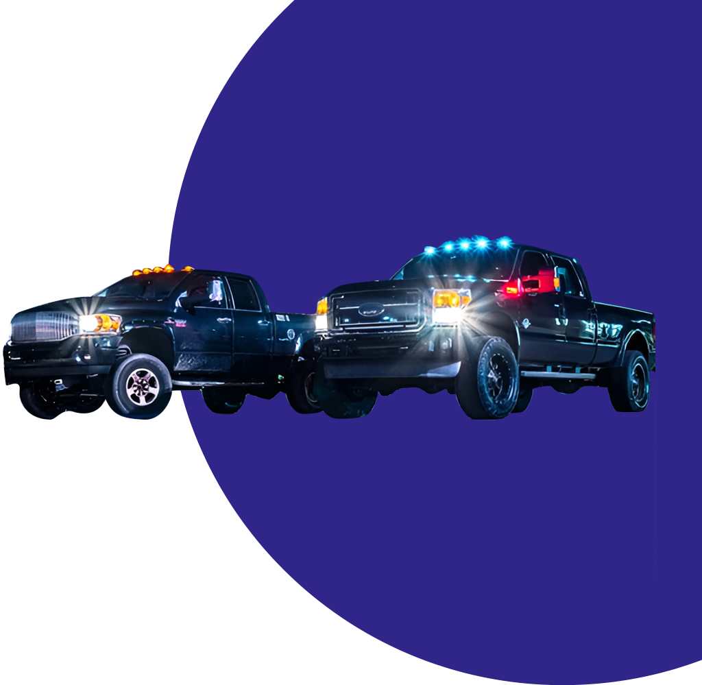 A truck and car are stopped in the dark.