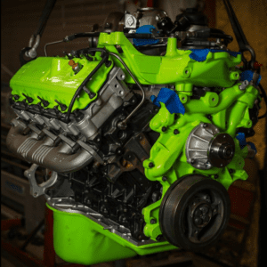 Bright green automotive engine in workshop.